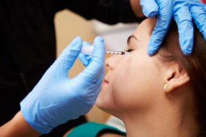 Woman patient getting facial injection.