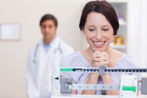 Happy patient on a medical scale