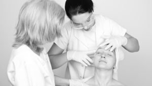 Black and white photo of doctor examining female patient