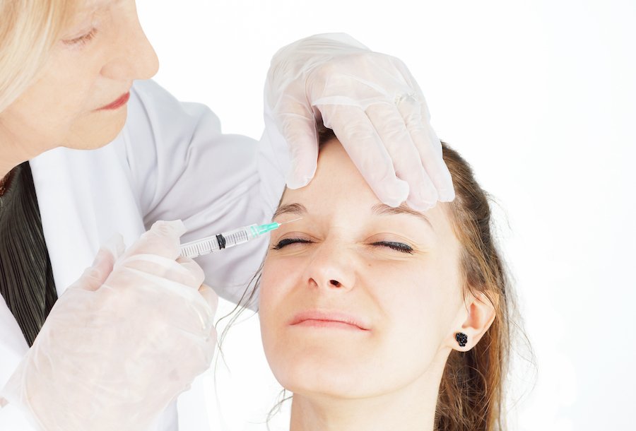Femal doctor injecting Botox to face of female patient