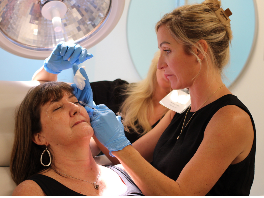 Medical provider attending hands-on Botox training in a clean dermatology clinic